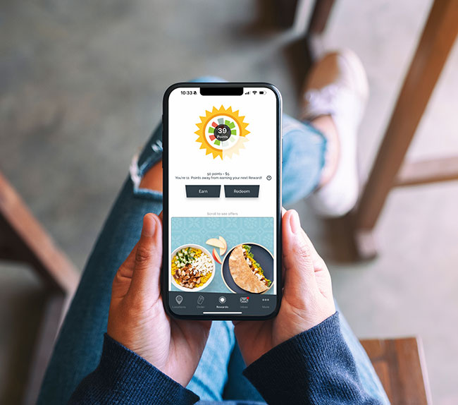 woman holding phone with rewards app